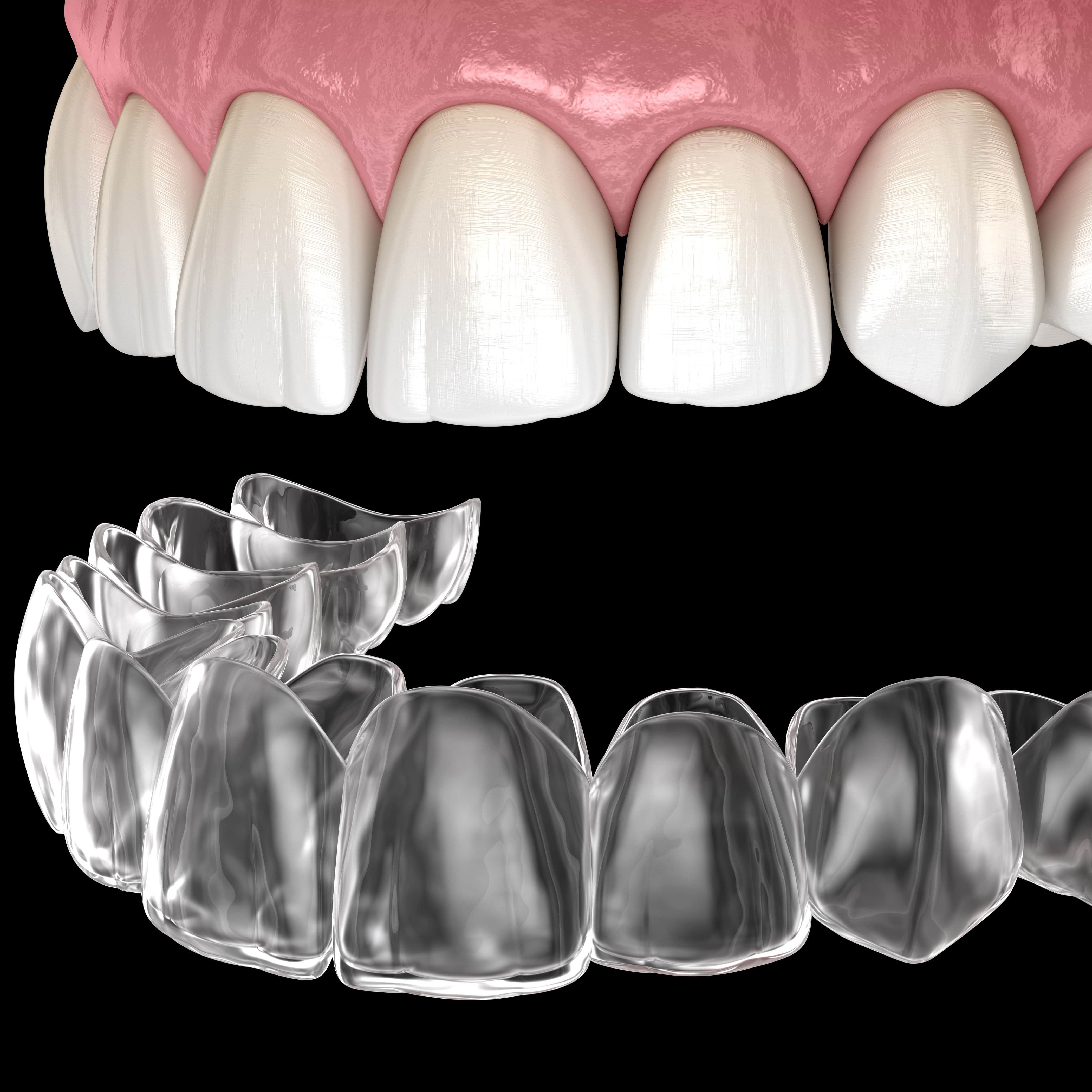 A man with a beard is wearing a white shirt and smiling with his arms crossed.