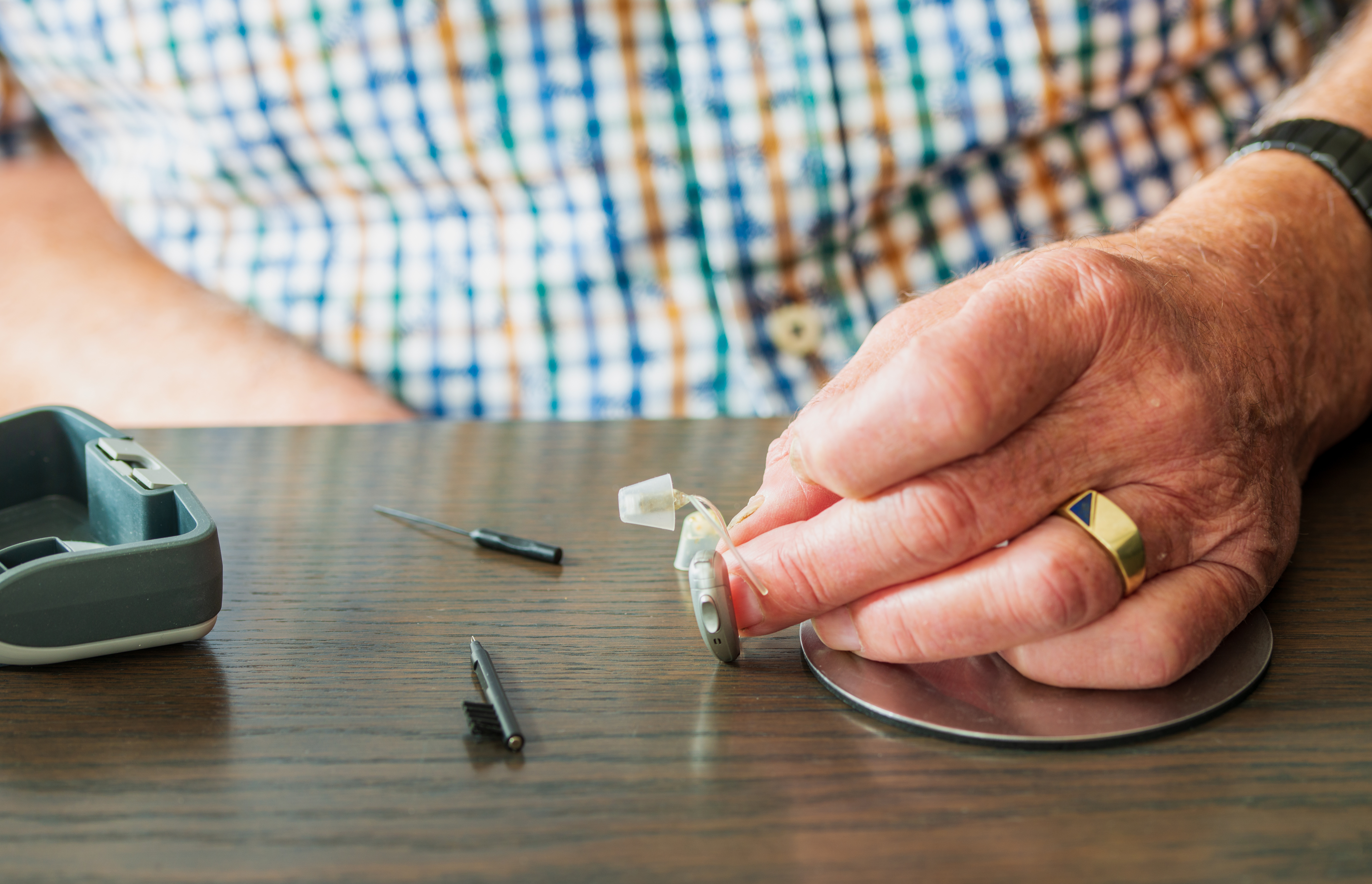 A Senior man Cleaning the Hearnig Aid