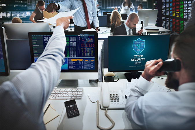 An office full of people with laptops that have numbers on it and the words 'cyber security' on the screen